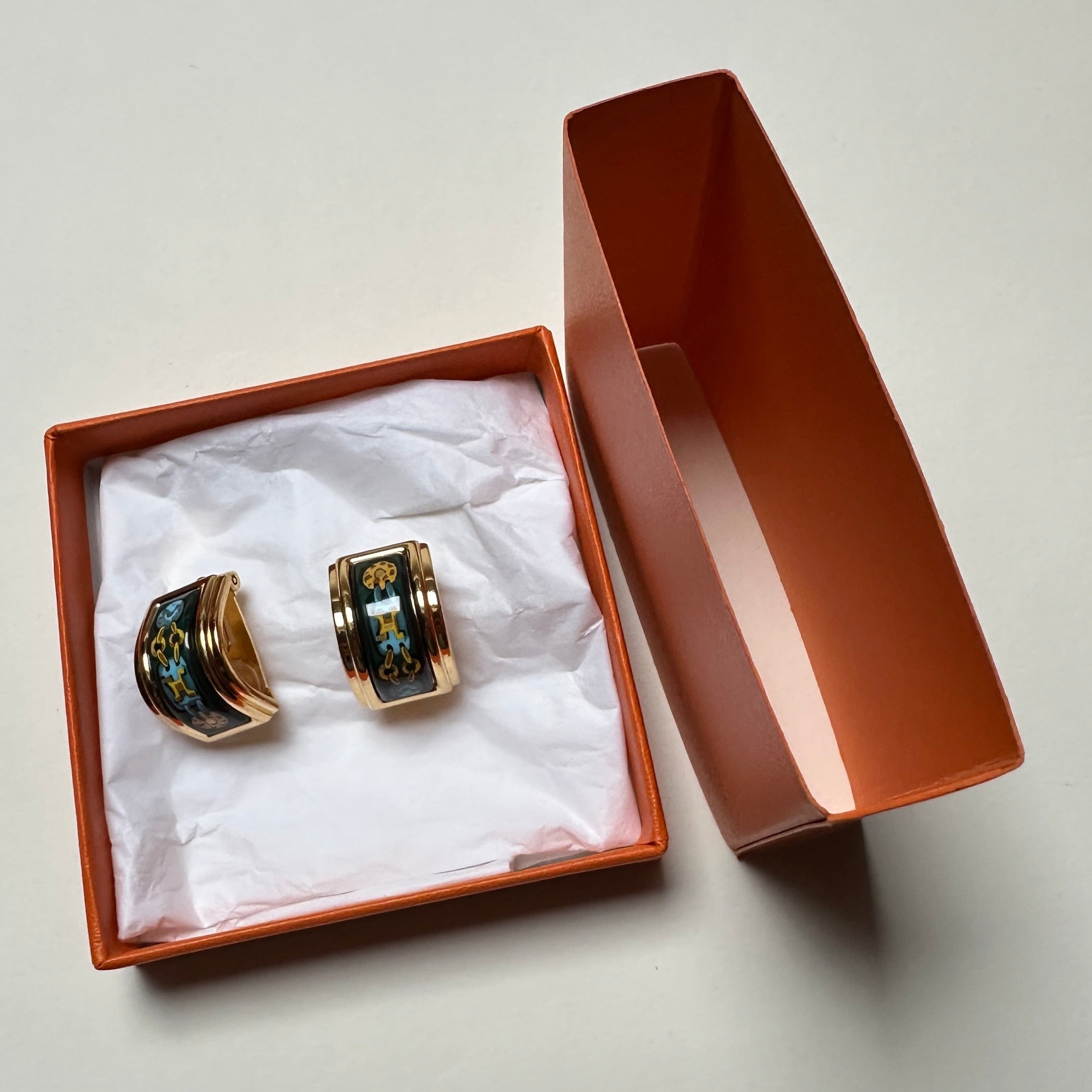 Boucles d'oreilles Hermès style couture dans leur écrin orange avec papier de soie.