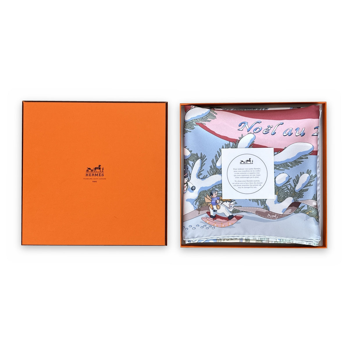 Carré Hermès Noël au 24 Faubourg Rybaltchenko 90 cm soie bleu ciel, plié dans sa boîte Hermès orange