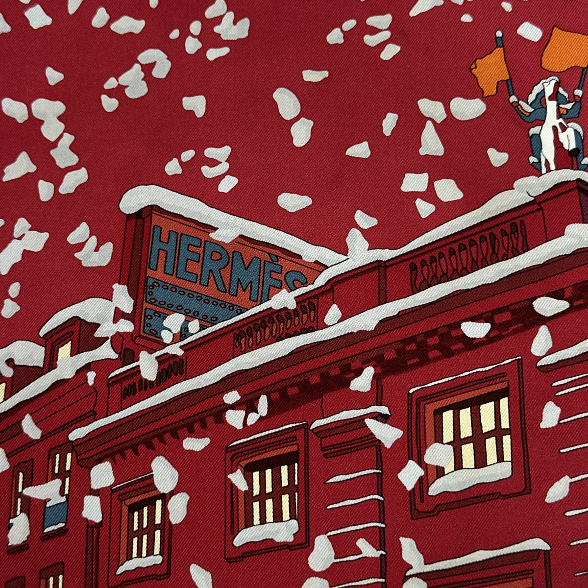 Carré Hermès Noël au 24 Faubourg Rybaltchenko 90 cm soie rouge, façade enneigée et enseigne Hermès