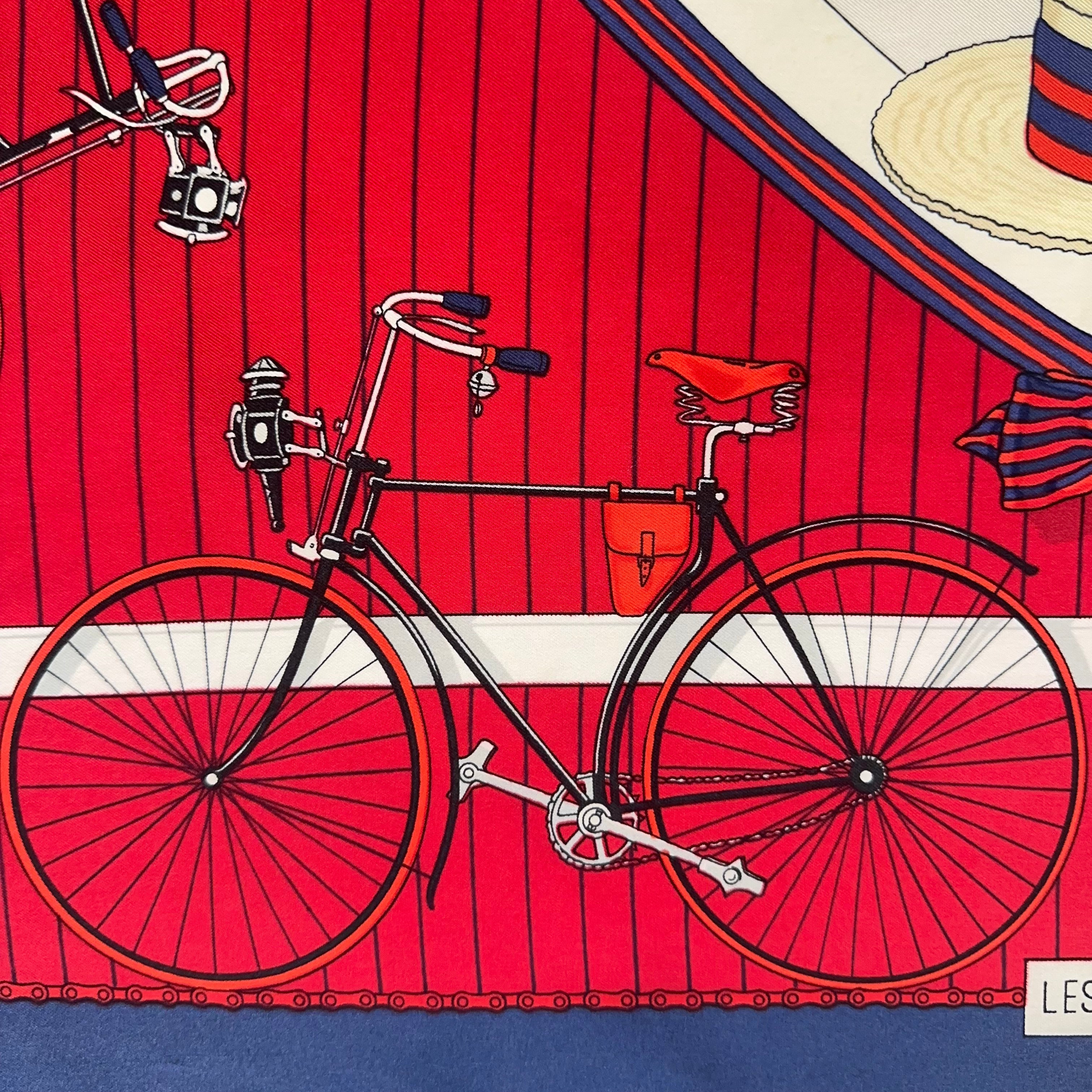 Détail de la bordure rouge : dessin précis d'un guidon de vélo ancien avec lampe à acétylène et sacoche en cuir.