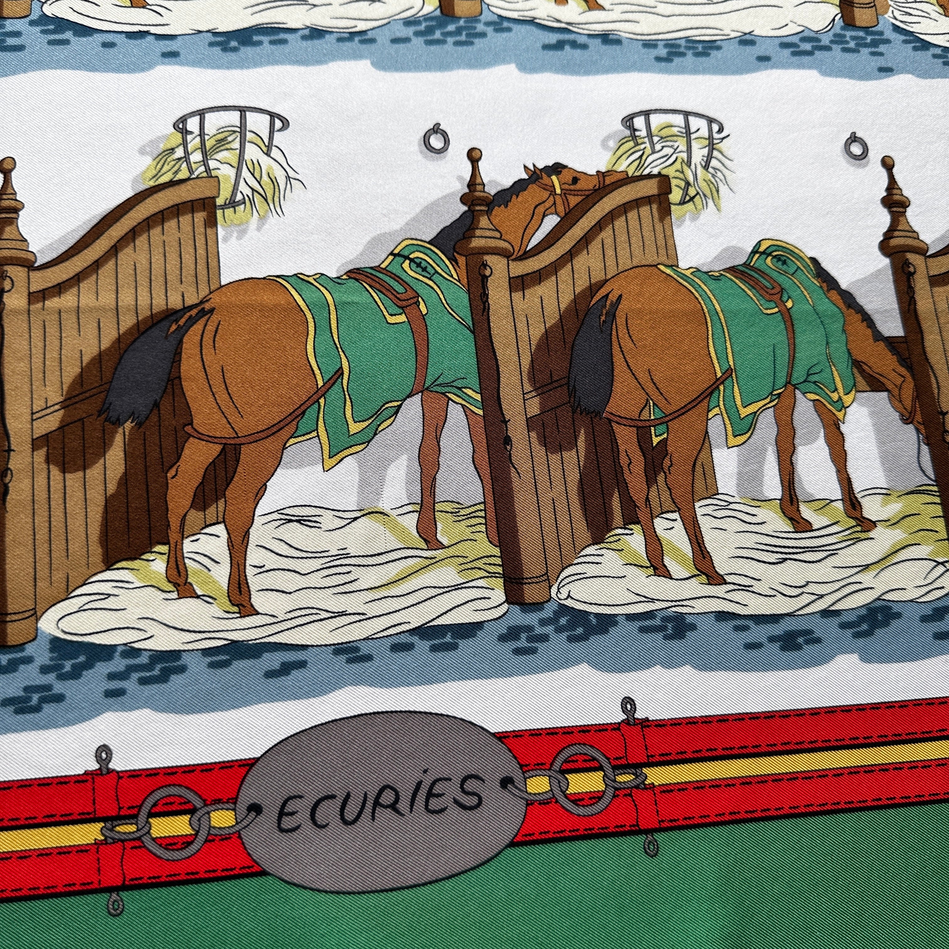 Détail motif chevaux à l'écurie et couvertures rouges