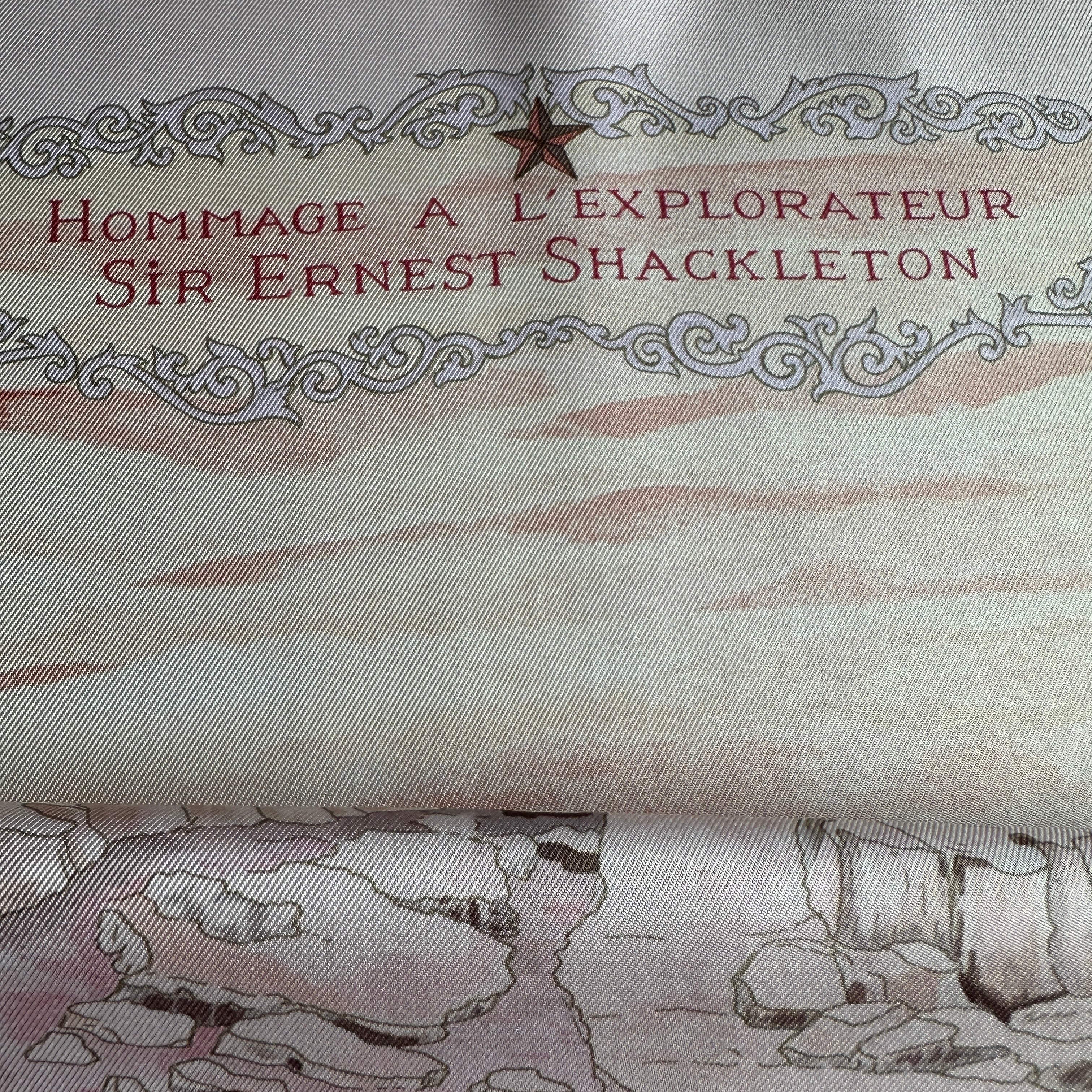 Zoom sur le titre "Hommage à l'explorateur Sir Ernest Shackleton" inscrit en lettres bordeaux en haut du foulard.