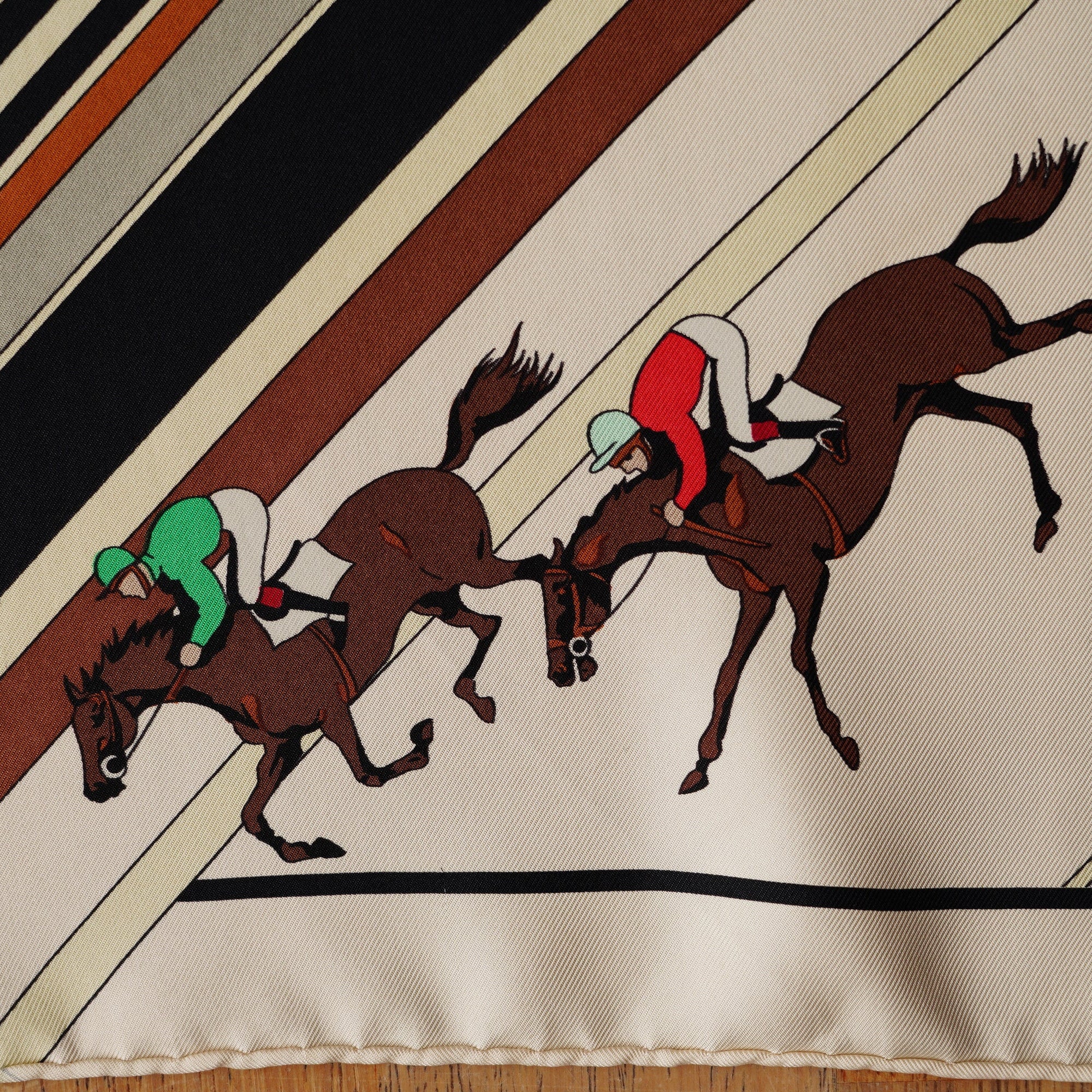 Vue rapprochée sur un groupe de jockeys franchissant la piste centrale du carré Hermès "Les Courses".