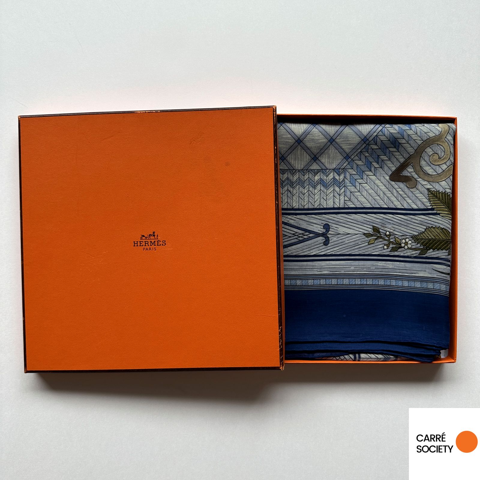 Foulard Hermès Jeux de Paille soigneusement plié dans sa boîte orange Hermès